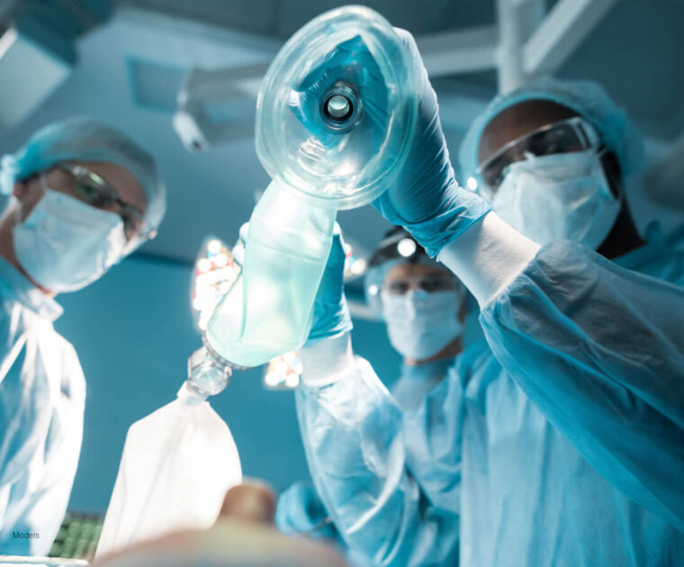 Group of anesthesiologists holding an oxygen mask.