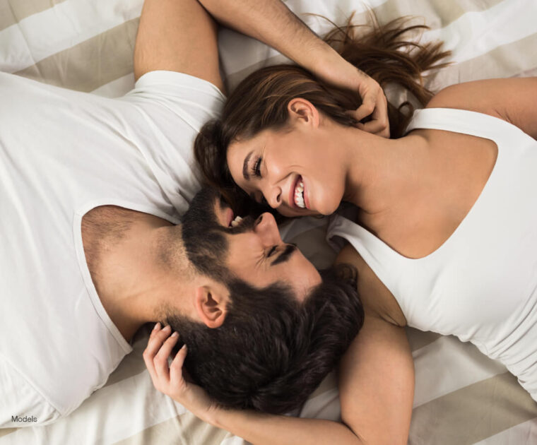 Young couple snuggling in bed.