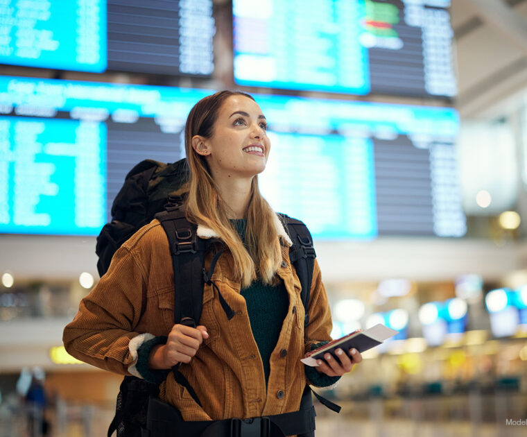 Excited young woman arrives in an airport terminal