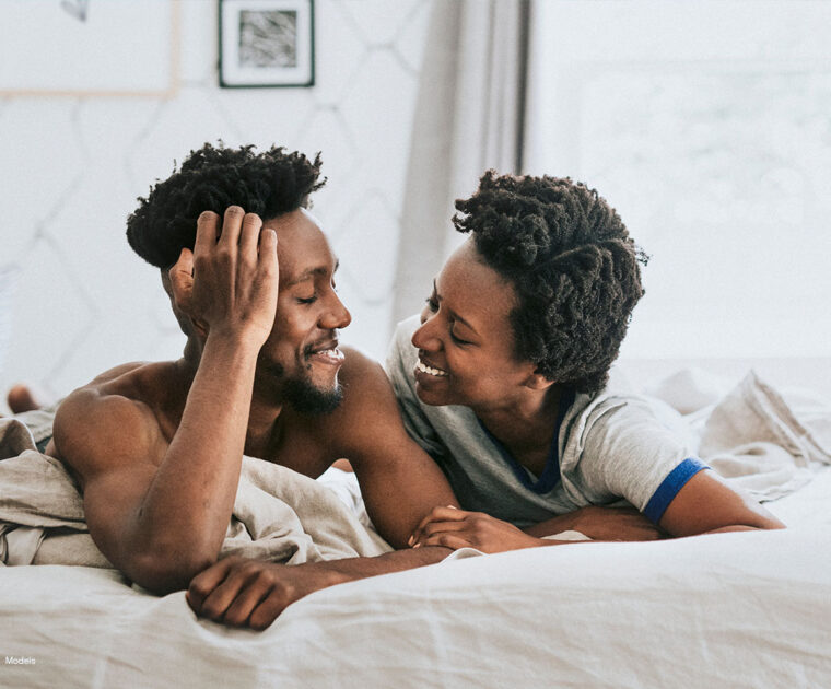 Cute happy couple playing in bed